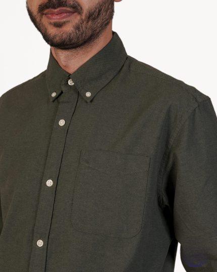 پیراهن مردانه آستین بلند سبز زیتونی با یقه Button-Down و جیب سینه، روی تن مدل مردانه.
